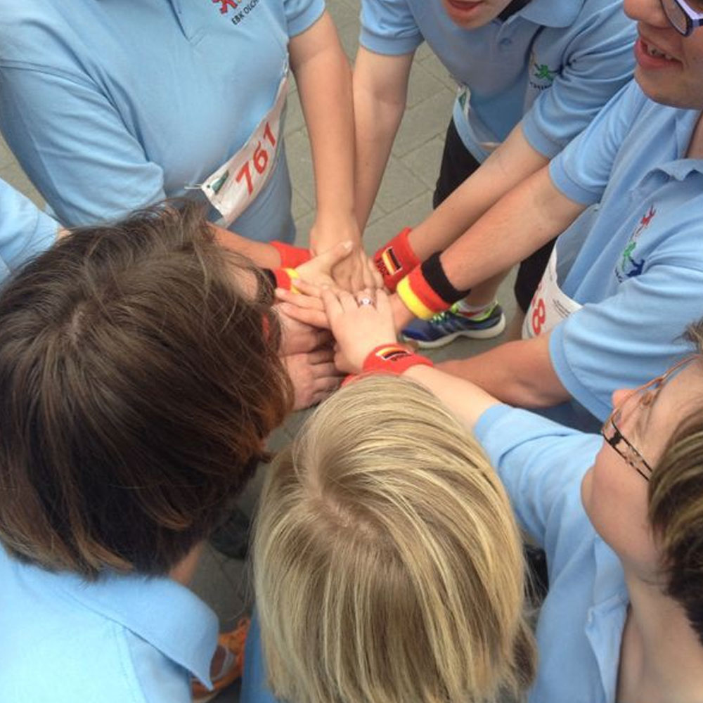 Kreis von Menschen mit allen Händen in der Mitte